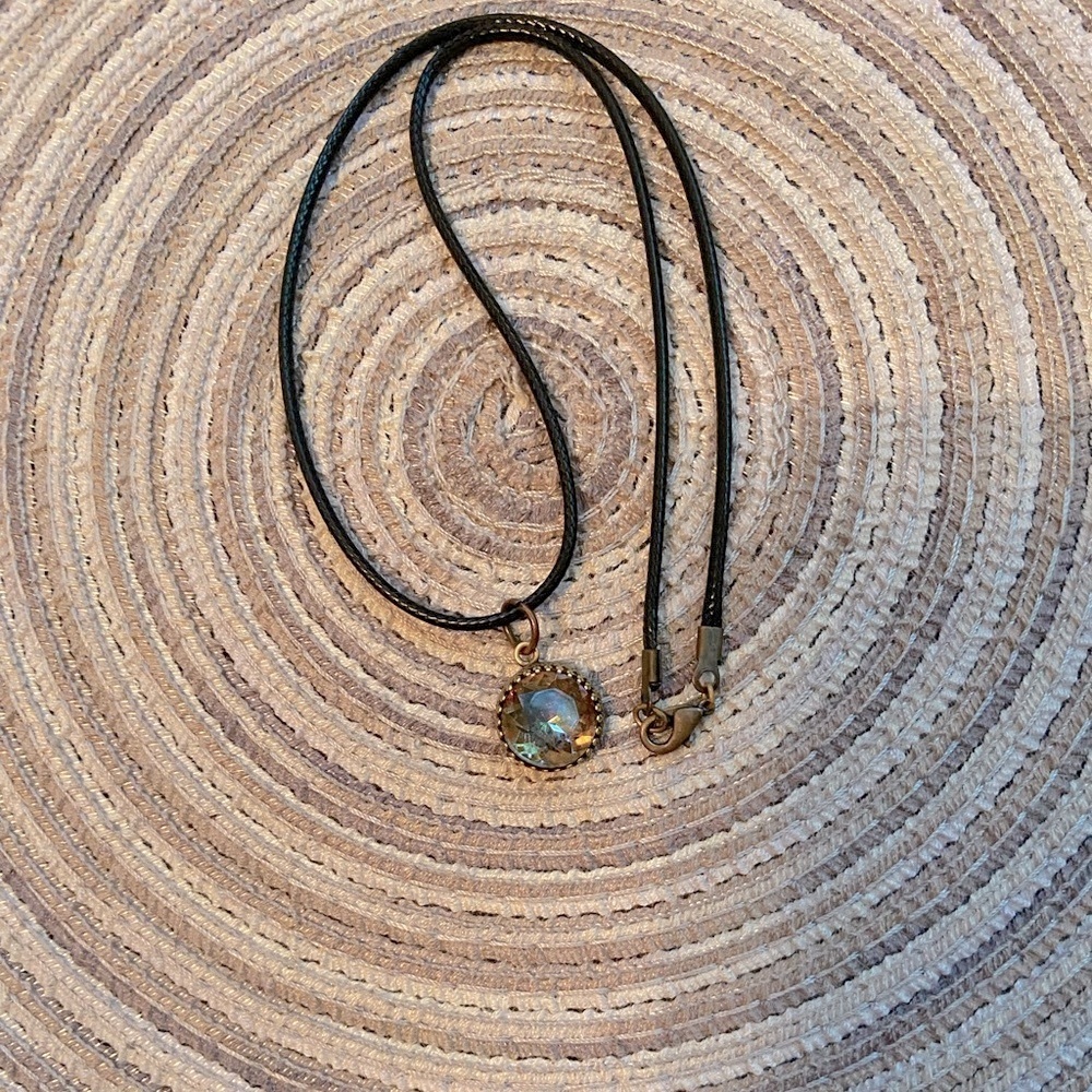 Swarovski pendant on black waterproof cord with gold lobster claw closure.